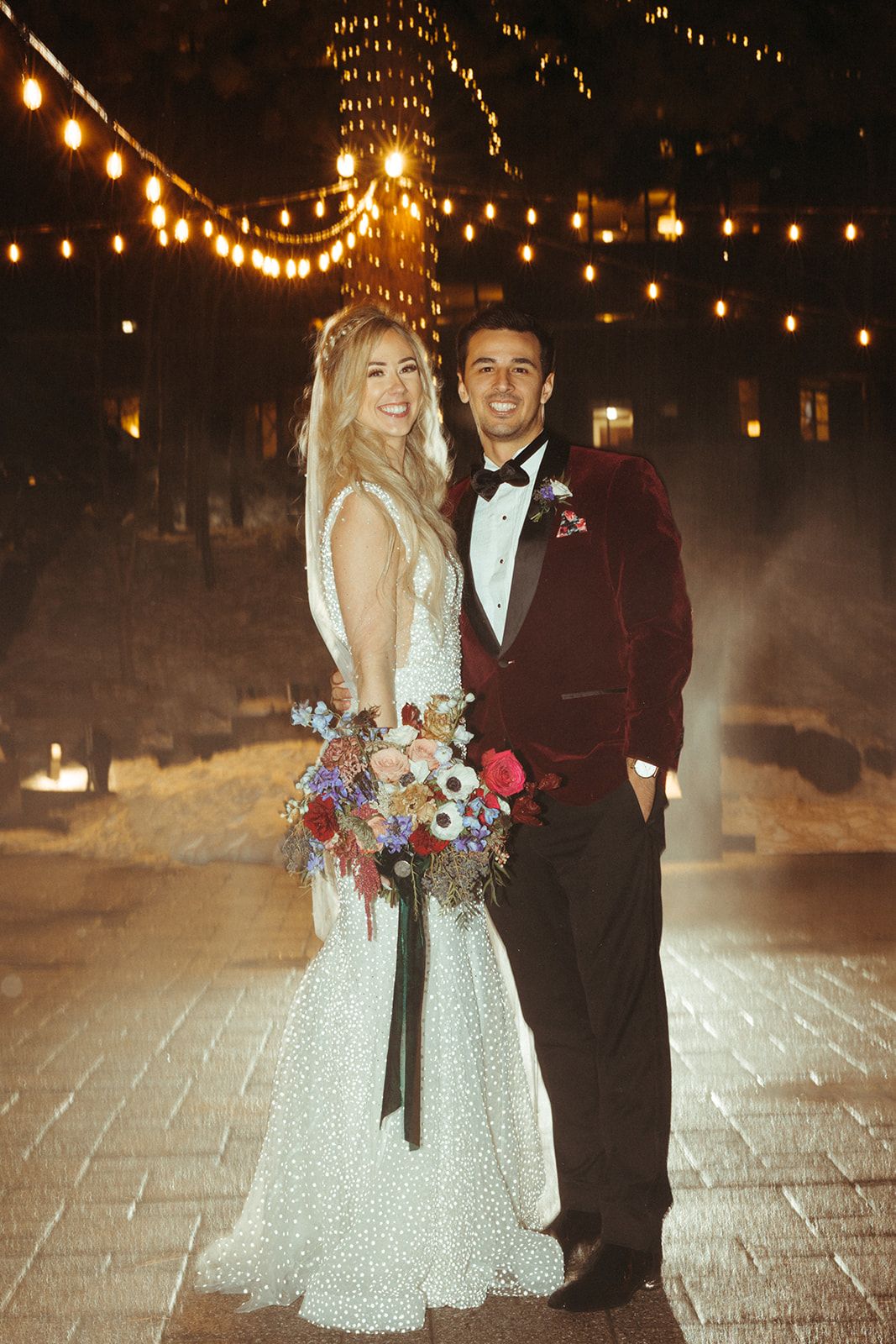 Andres in a burgundy velvet tuxedo with his bride