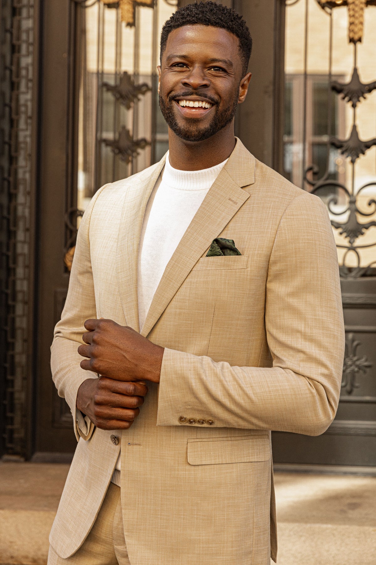 A smiling man in a cream suit and white tee in downtown Chattanooga
