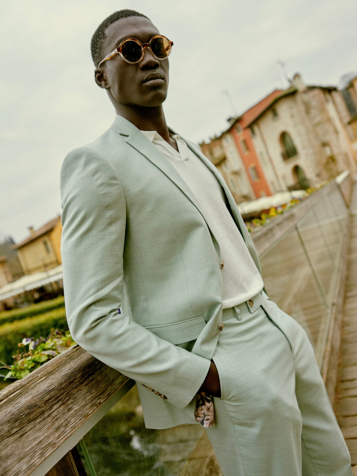 A man in a mint suit on a bridge in Sirmione, Italy