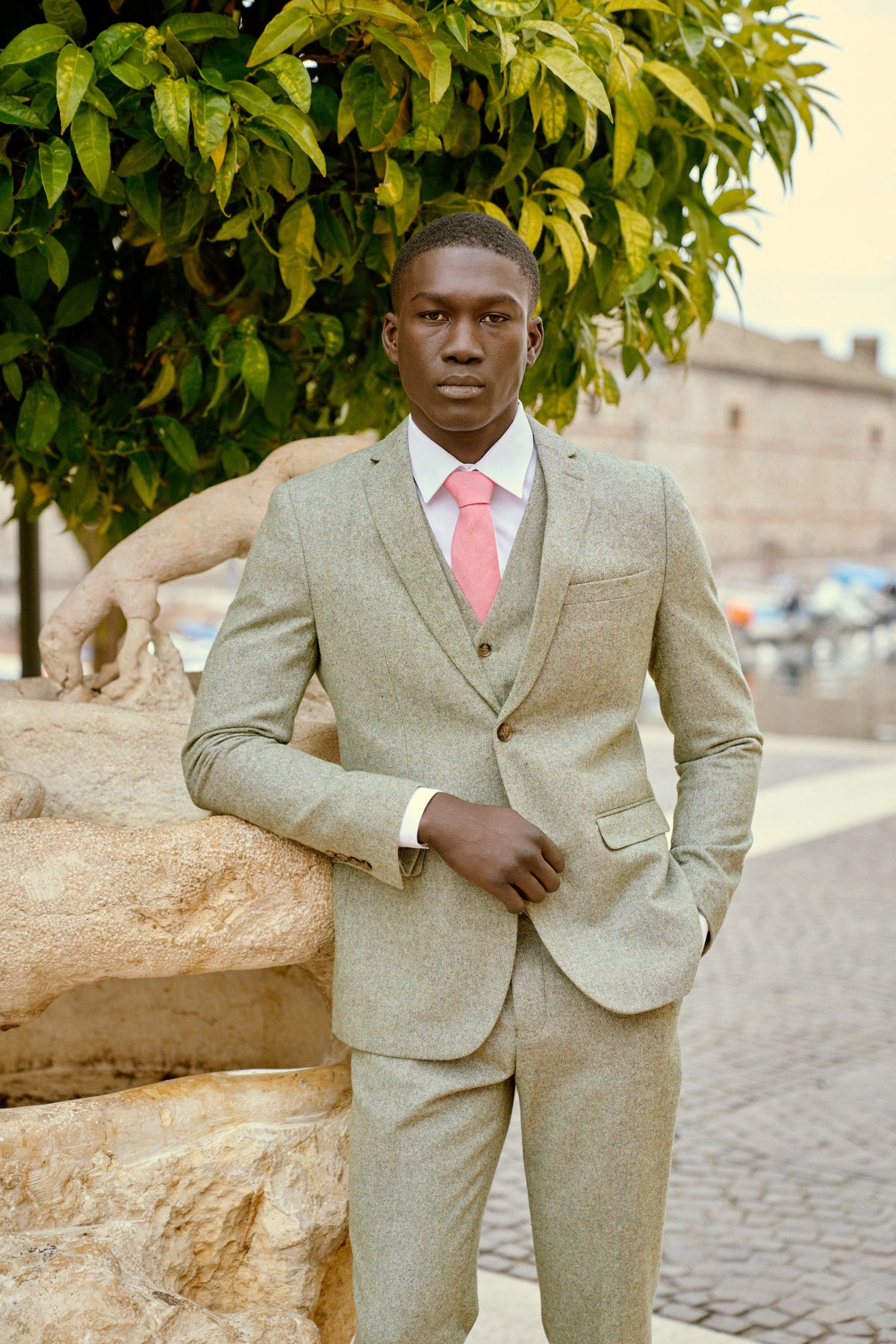 A man in a sand three-piece suit and pink tie in Italy