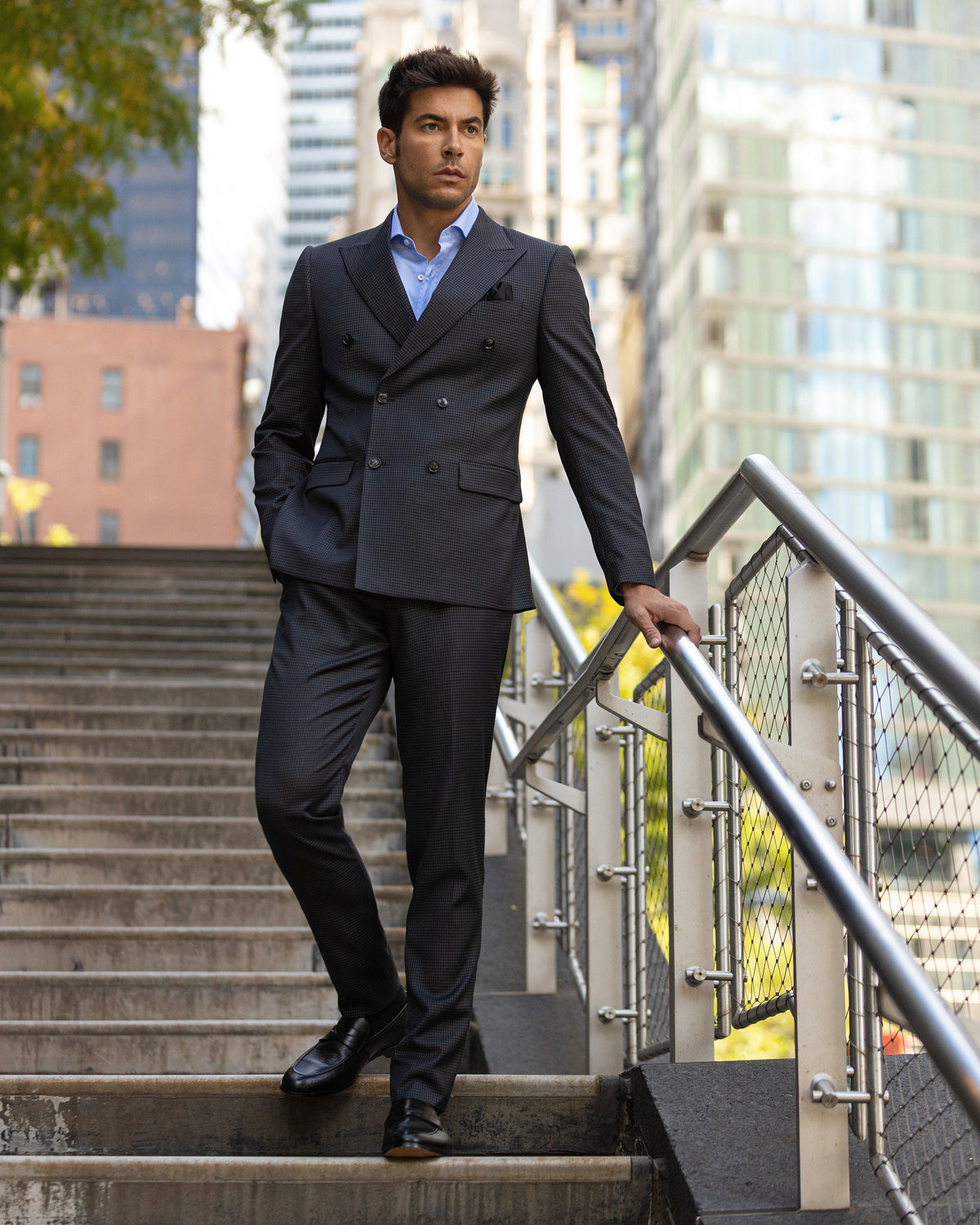A man in a navy double-breasted suit on outdoor steps