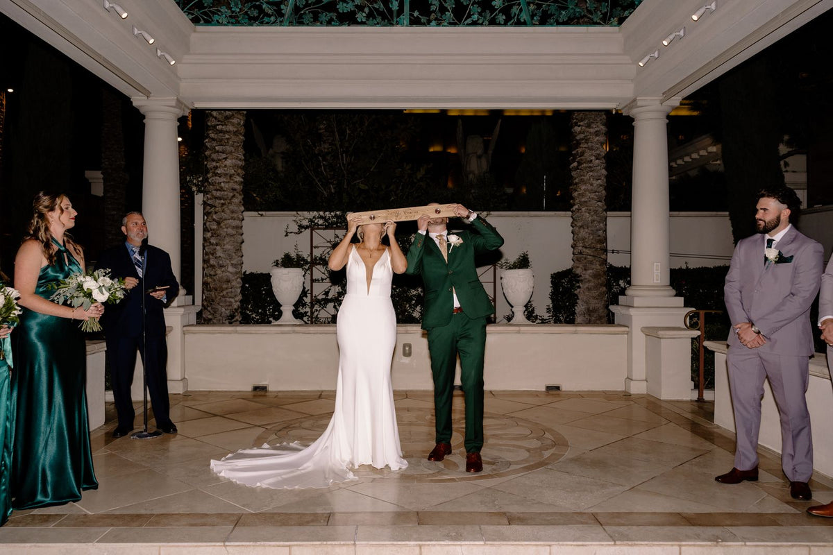 Cobi in a forest green suit with his bride