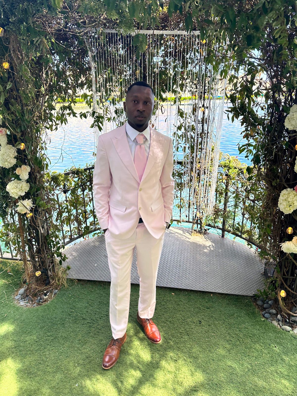 Marcus in a blush pink suit at his ceremony